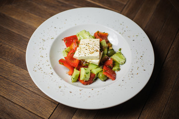 Fresh healthy greek salad on wooden table. View from above