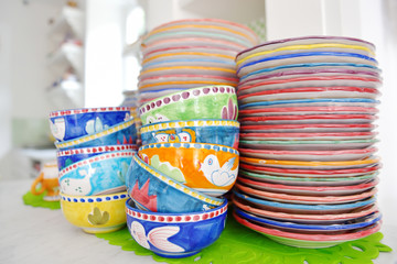 stack of colorful hand painted ceramic bowls and plates
