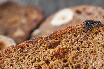 Rye bread background, slices with nuts and raisins close-up. Cereal bakery backdrop