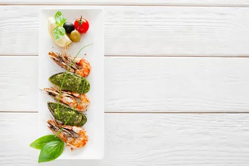 Wall murals Sea Food Plate with prepared seafood on white wooden background, copy space. Vertical position of dish with stuffed mussel and grilled shrimp, menu photo, free space for text