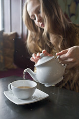 Beautiful Girl Drinking Tea or Coffee in Cafe