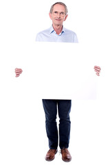 Senior salesperson holding blank whiteboard