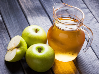 Apple juice in pitcher on wooden table still life