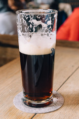 Glass of dark beer half-full in a restaurant interior