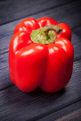 fresh raw red sweet pepper on a wooden table vertical still life