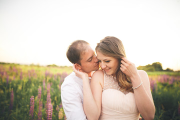 Beautiful wedding couple, love on the sunset. Fielf with flowers