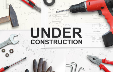 Under construction text with tools for home repairs. Top view. - obrazy, fototapety, plakaty