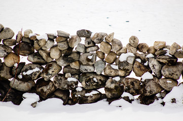 Stone wall on snow-covered ground