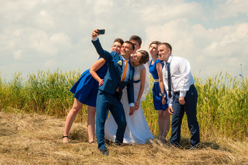 The bride, groom, bridesmaid and best man doing surf on a field of hay