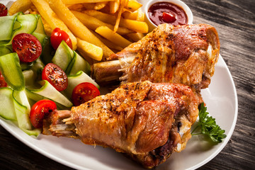 Grilled turkey legs with chips and vegetables 