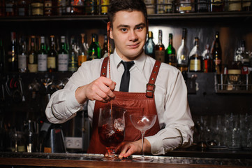 Bartender is stirring cocktails on the bar counter