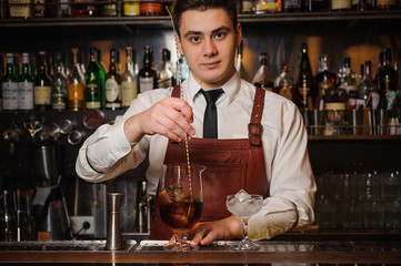 Bartender is stirring cocktails on the bar counter