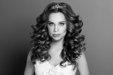 Fashion portrait of young woman with magnificent curly hair. Per