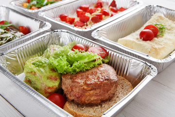 Healthy food take away in boxes, top view at wood