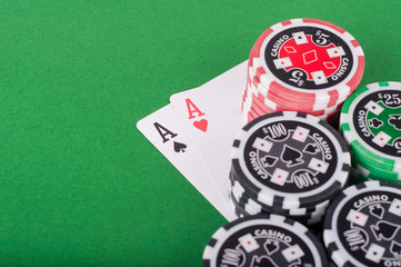 pair of aces, red and black cassino chips on green table © michaldziedziak