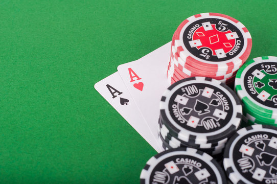 pair of aces, red and black cassino chips on green table