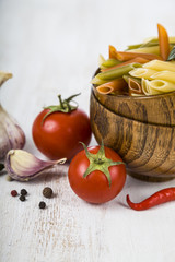 Raw pasta and spices in wooden bowls