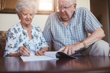Senior husband and wife doing paperwork together at home