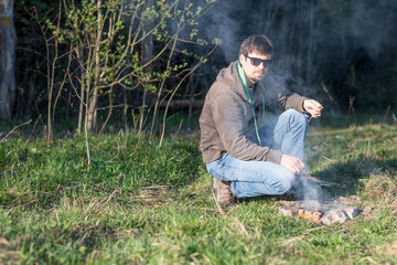 Naklejka na ściany i meble man at a picnic by the bonfire