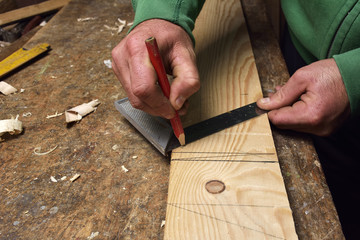 carpenter working with plane on wooden