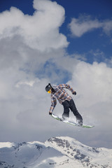 Naklejka na ściany i meble Snowboarder jumps high in the mountains.