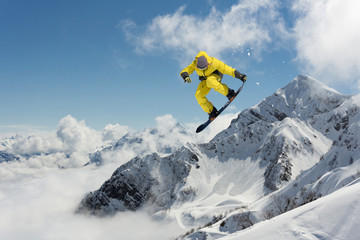 Snowboarder jumps high in the mountains.