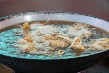 Fry fish  food in hot oil in black pan
