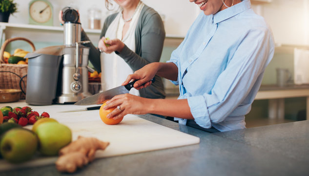 Women at bar counter preparing juice