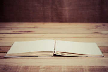 Vintage book on grunge wooden floor with Sackcloth texture backg