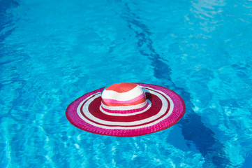 Fototapeta na wymiar Pink sunhat at swimming pool