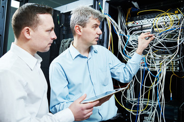 two network support engineers administrating in server room