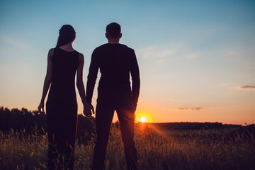 Love story . Couple at sunset. On the background of the sky. Clouds.