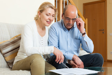 serious elderly couple with financial documents