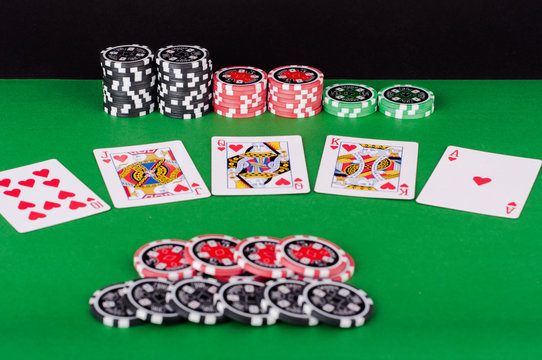 green casino table with royal flush, red and black chips