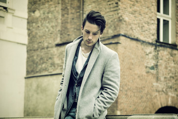 Fototapeta na wymiar Elegant attractive young man outdoor wearing wool coat, in European city