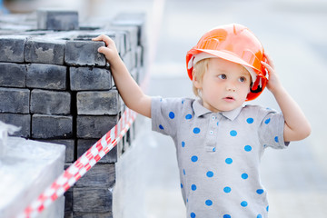 Little builder in hardhats working outdoors