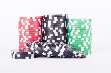 Black, red and green casino chips isolated on white