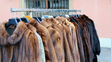 many fur coat for sale in the flea market outdoors