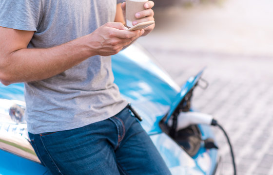 Man using smartphone while charging car