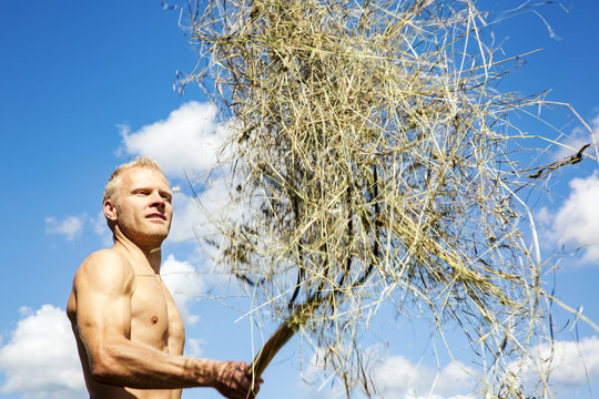 Man turns hay in the meadow