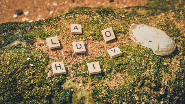 Top view on "Holiday" wooden sign pazzle abstract design on the beach background