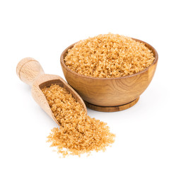 brown cane sugar in a wooden bowl isolated on white