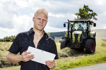 Man with tablet PC in haymaking