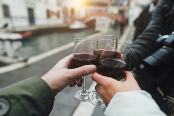 Tourists drink wine and talk toast in Venice, Italy