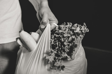Black and white close up of person hold shopping bag in hand