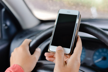 Car driver using smart phone, closeup on hand, mockup screen background