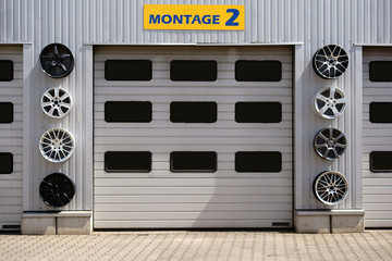 Autowerkstatt / Eine Autowerkstatt mit mehreren Garagen und Sportfelgen zur Dekoration.