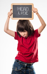 cheeky young child making brave funny face against head lice