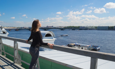 beautiful female tourist walking on the roof admiring the city from a height