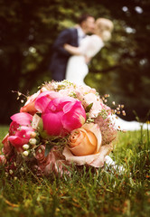 Hochzeitspaar küsst sich hinter Brautstrauß